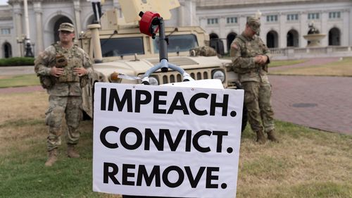 A demonstrator protests next to members of the South Carolina National Guard.