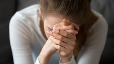 Woman hunching over crying