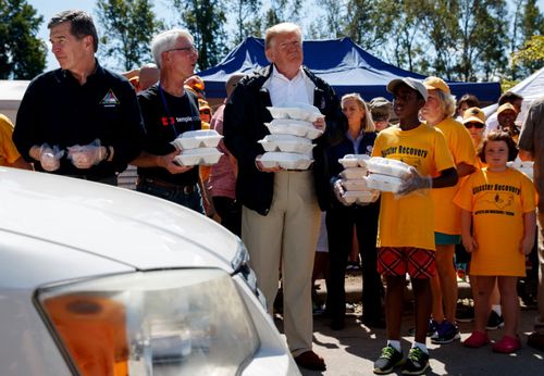 US President Donald Trump helps with flood relief supplies in North Carolina.
