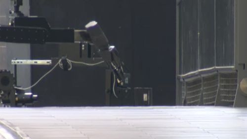The bomb squad robot carefully opened the box outside Southern Cross Station. (9NEWS)