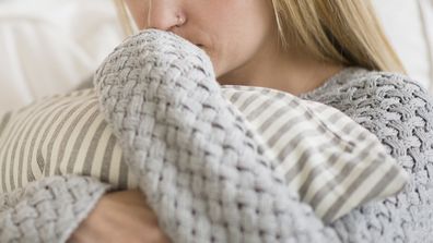 Sad woman hugging pillow