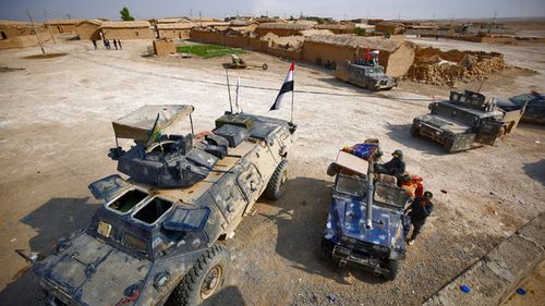 Iraqi forces enter the village of al-Khuwayn, south of Mosul, after recapturing the village from Islamic State (IS) group jihadists on October 23, 2016, in part of an ongoing operation to tighten the noose around Mosul and reclaim the last major Iraqi city under IS control. 
AHMAD AL-RUBAYE / AFP