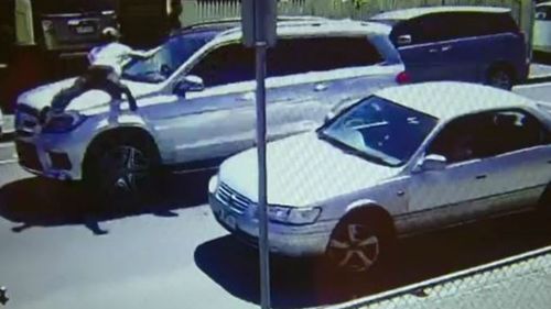 The mother's friend can be seen desperately latching onto the Mercedes' bonnet. (9NEWS) 