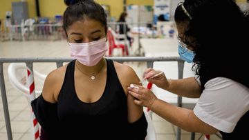 A healthcare worker administers a booster dose of a COVID 19 vaccine at a temporary vaccine centre in Guatemala City, Tuesday , March 1, 2022