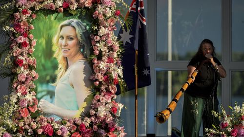 In this Aug. 11, 2017, file photo, Johanna Morrow plays the didgeridoo during a memorial service for Justine Ruszczyk Damond at Lake Harriet in Minneapolis.