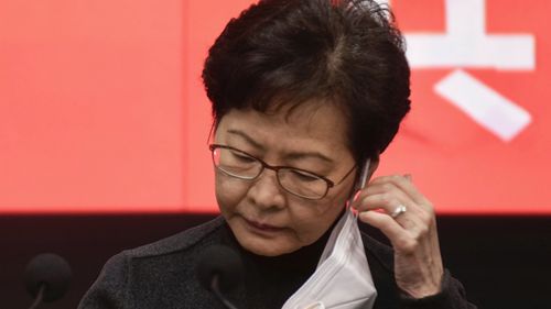 Hong Kong Chief Executive Carrie Lam takes off her face mask before a press conference in Hong Kong.