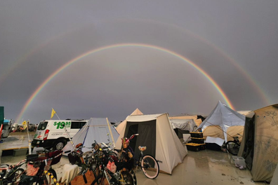 Casey Donovan snaps a photo of a rainbow over a campsite during the flooded Burning Man Festival in 2023.