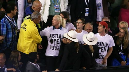 Demonstrators are removed from Rod Laver Arena after they protested for the closure of an offshore detention centre on Manus Island during the Australian Open final. (Getty Images)