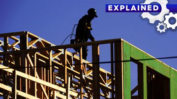 A construction worker on a partially-built house.