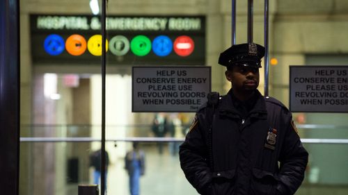 A police officer stands outside Bellevue Hospital, where Dr Spencer has been taken for treatment. (Getty)