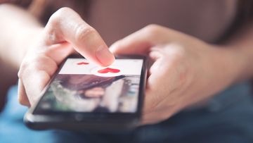 A woman uses a dating app on her mobile phone.