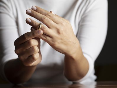 Hands of caucasian female who is about to taking off her wedding ring.