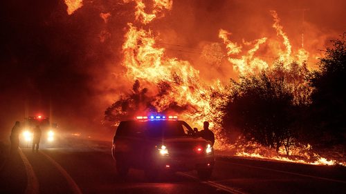 Flames lick above vehicles on Highway 162 as the Bear Fire burns in Oroville, Calif., on Wednesday, Sept. 9, 2020. (AP Photo/Noah Berger)