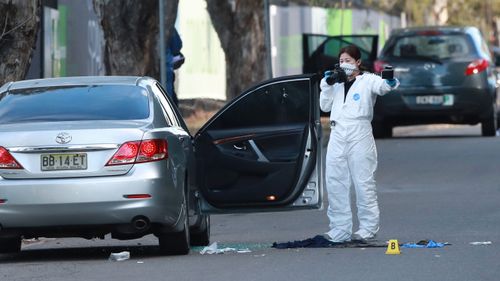 La scène de la fusillade à Greenacre.  Deux hommes et une femme ont été abattus alors qu'ils étaient assis dans leur voiture.  Des trous de balle sont visibles dans la fenêtre de la voiture.