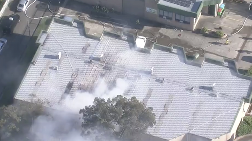 Thick plumes of smoke are seen blowing from the factory's roof.