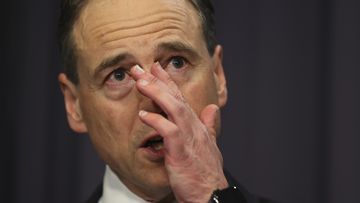 Minister for Health and Aged Care Greg Hunt sheds a tear when speaking about threats to his family, during a press conference. 