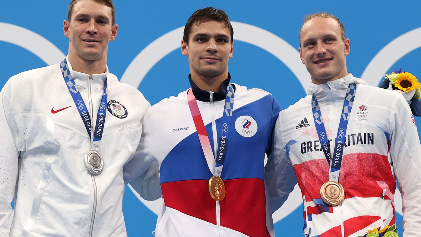 Silver medallist Ryan Murphy of Team United States, gold medallist Evgeny Rylov of Team ROC and bronze medallist Luke Greenbank of Team Great Britain pose on the podium during the medal ceremony for the Men&#x27;s 200m Backstroke Final at the Tokyo Olympics.