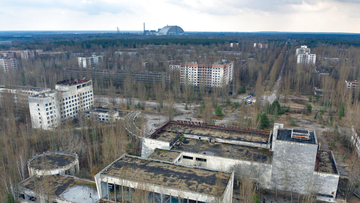 A view of the ghost town of Pripyat with a shelter covering the exploded reactor at the Chernobyl nuclear plant in the background. 