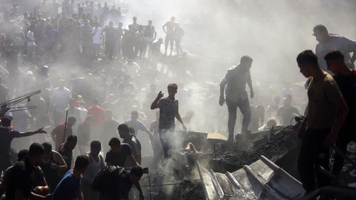 Palestinians inspect the rubble of destroyed buildings following Israeli airstrikes on the town of Khan Younis, southern Gaza Strip, Thursday, Oct. 26, 2023.