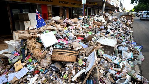 Piles of flood-damaged goods line a main street in central Lismore as residents are returning to their properties to survey the damage. 