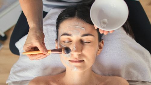 woman getting a facial beauty treatment skin relax beautician face mask