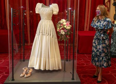 Princess Beatrice poses alongside her wedding dress as it goes on display at Windsor Castle on September 23, 2020 in Windsor, England