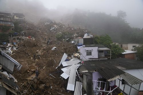 Salvatori și rezidenți caută victime într-o zonă afectată de alunecări de teren din Petropolis, Brazilia, miercuri, 16 februarie 2022.