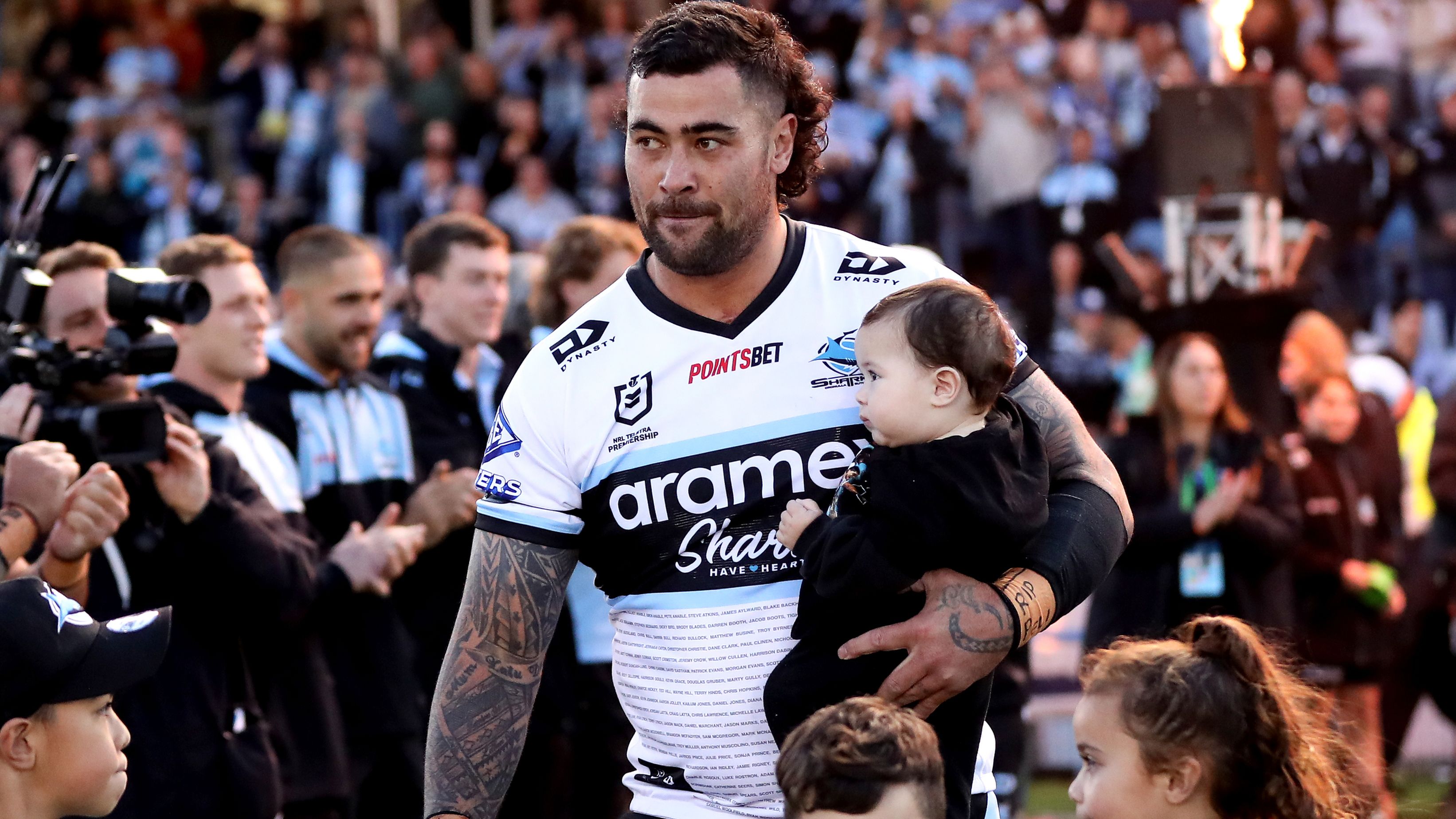 Andrew Fifita of the Sharks walks onto the field with his family.