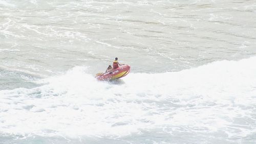 A surf lifesaver heads out into the water in Sydney's south after a shark sighting.