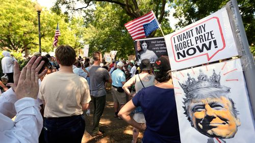 Arquivo - Os ativistas carregam sinais durante um protesto contra a aquisição federal do presidente Donald Trump do policiamento do Distrito de Columbia, sábado, 16 de agosto de 2025, em Washington. (AP Photo/Alex Brandon, arquivo)