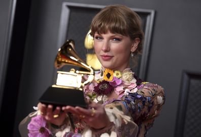 Taylor Swift poses in the press room with the award for album of the year for "Folklore" at the 63rd annual Grammy Awards at the Los Angeles Convention Center on Sunday, March 14, 2021 