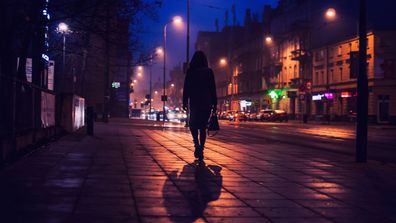 Dark street with woman walking alone