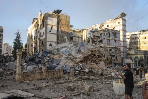 A man documents the damaged buildings at the site of an Israeli airstrike in Dahiyeh, Beirut, Lebanon, Friday, Oct. 4, 2024 