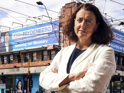 Independent for Kooyong Dr Monique Ryan at Camberwell Junction in Melbourne, standing in front of billboards of Josh Frydenberg.