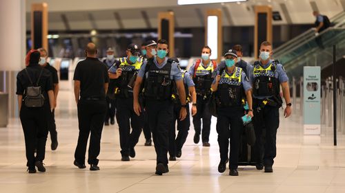 WA Police officers arrive ahead of international flight arrivals at the Perth International Airport Terminal 