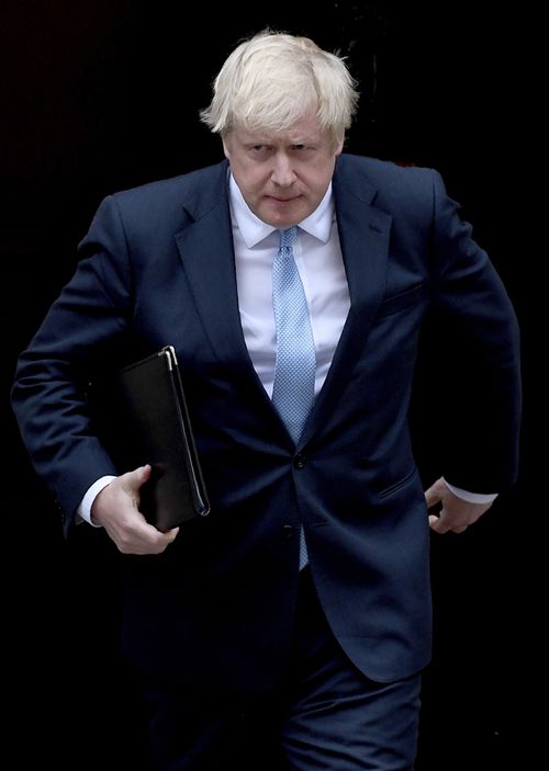 Prime Minister Boris Johnson walks towards a podium to speak to the media outside 10 Downing Street in London.