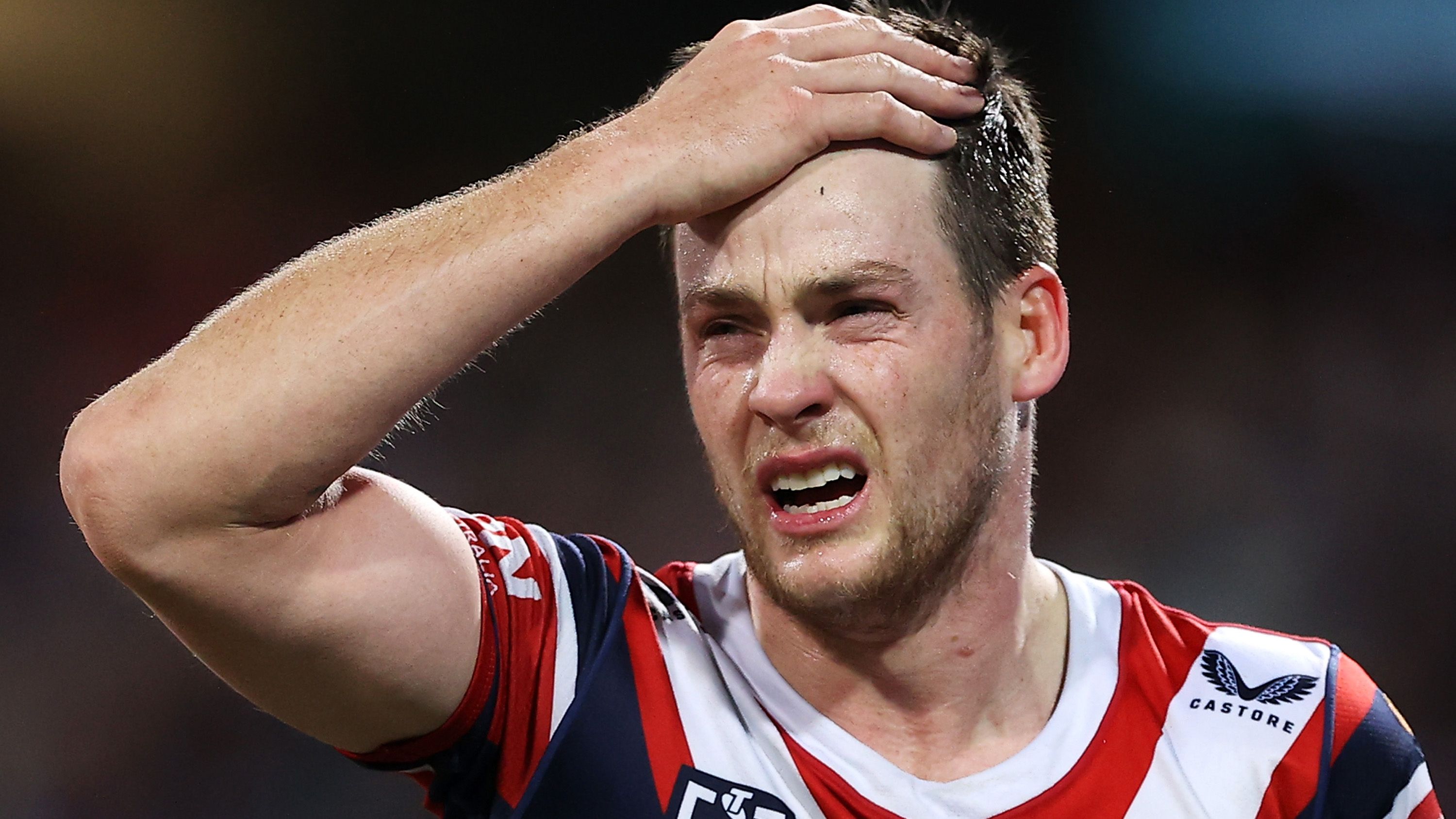 Luke Keary holds his head as he leaves the field for a HIA against the Storm on Saturday night. (Photo by Mark Kolbe/Getty Images)