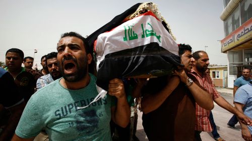 Iraqi men carry a coffin in the holy Iraqi city of Najaf during a funeral procession for victims. (AFP)