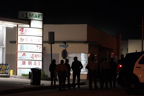 Law enforcement personnel walk toward a scene where a shooting took place after holding a briefing in Monterey Park.