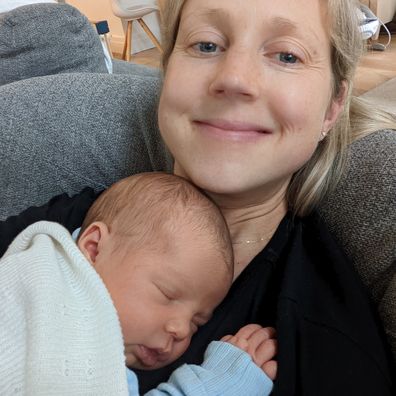 Vanessa Hutchinson with her second child, daughter Maya asleep on her chest.