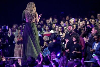 Honored Jennifer Lopez receives the Icon Award on stage, while Ben Affleck reacts among the audience at the 2022 iHeartRadio Music Awards at The Shrine Auditorium in Los Angeles, California on March 22, 2022.