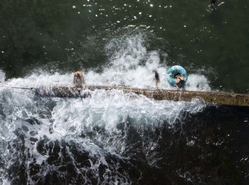 Nadadores se refrescam na piscina Oak Park Rock, em Sydney, em um dia escaldante de verão