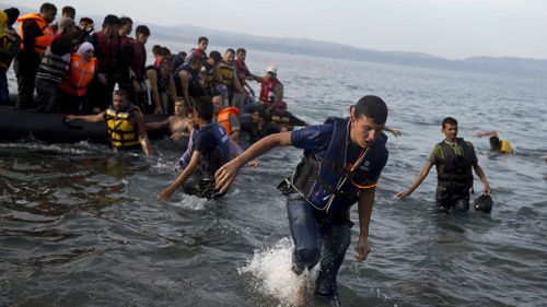 Syrian refugees arrive on a dinghy after crossing from Turkey to Lesbos island, Greece.