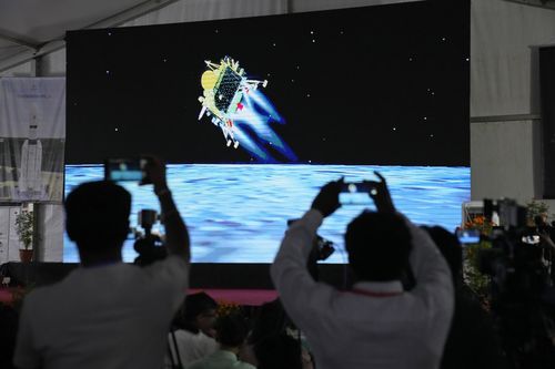 Journalists film the live telecast of spacecraft Chandrayaan-3 landing on the moon at ISRO's Telemetry, Tracking and Command Network facility in Bengaluru, India, Wednesday, Aug. 23, 2023. I
