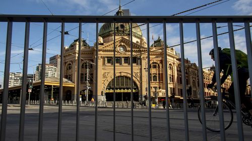 A cyclists passes an empty Flindres Street Station during lockdown due to the continuing spread of the coronavirus in Melbourne.