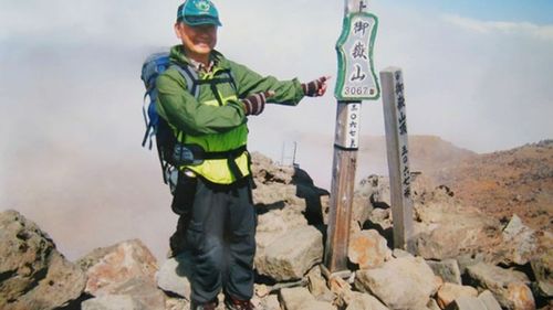 Noguchi, 59, poses on the summit shortly before the eruption.