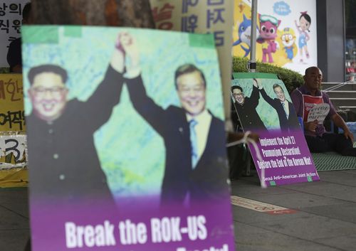 Photos showing North Korean leader Kim Jong Un, left, and South Korea President Moon Jae-in are displayed to demand withdrawal of U.S. troops from Korean Peninsula near the U.S. embassy in Seoul, South Korea