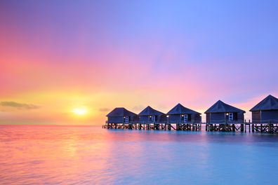 Sunset on Maldives island, water villas resort.