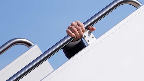 Joe Biden clings to the railing after slipping on the steps of Air Force One.