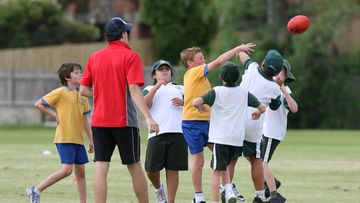 Under 9 and under 10 school children playing AFL